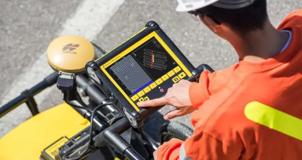 A construction worker using a tablet on a motorcycle.